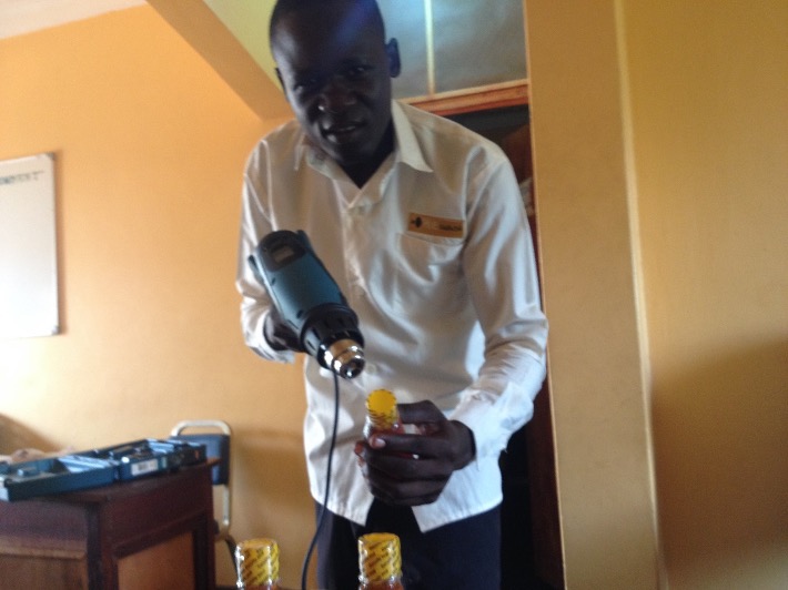 HIVE Uganda putting security seal using heat gun acquired