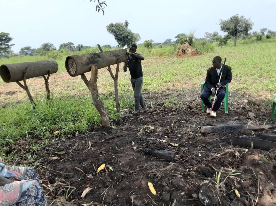 A guide preparing the lid for the local bee hive in one of the bee farm for a blind person